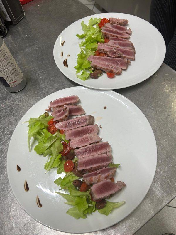 Due piatti di tagliata di tonno scottato con insalata