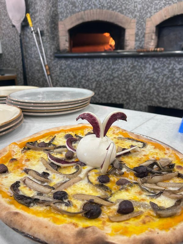 Pizza ai funghi con burrata, davanti al forno