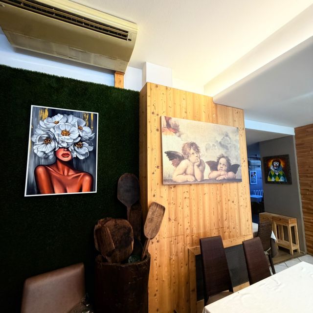 Angolo della sala con parete in legno e quadri